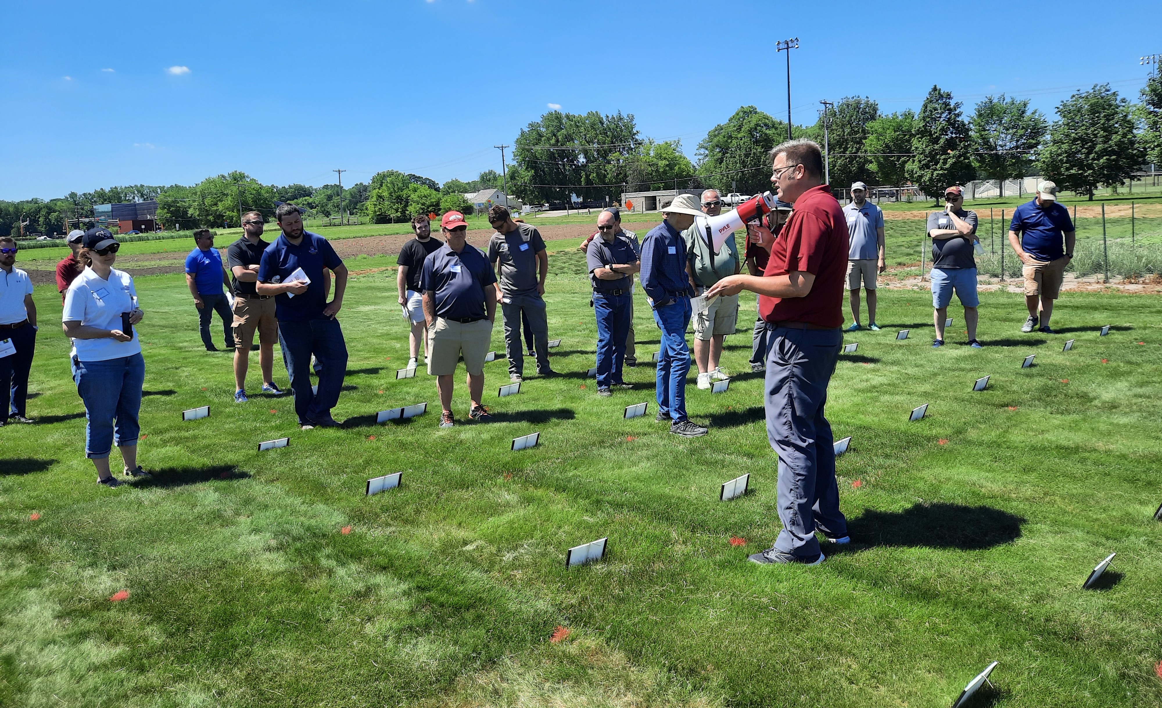 a man speaking to a group of turfgrass field day attendees