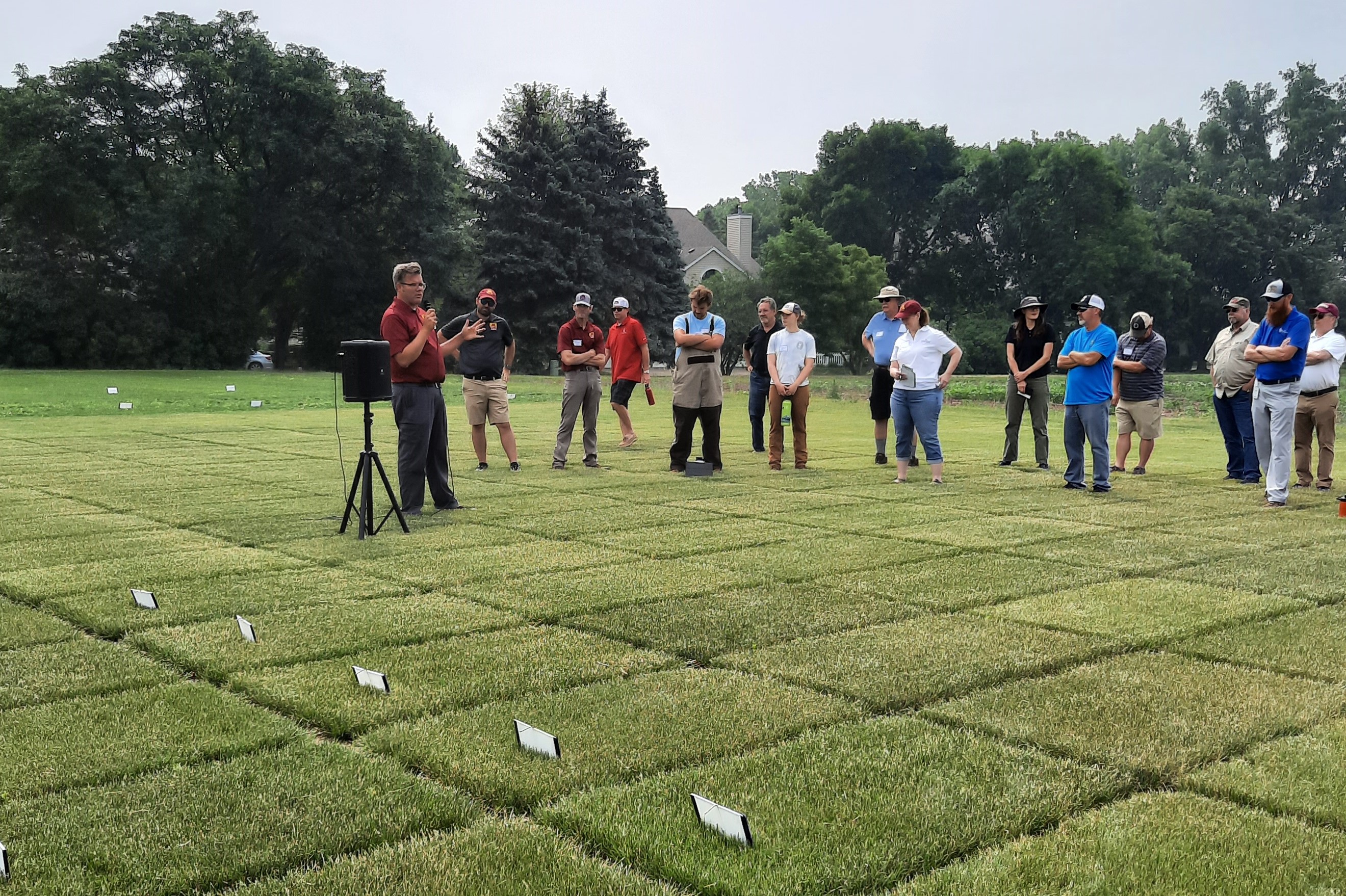 a man giving a talk outside at a turfgrass field day