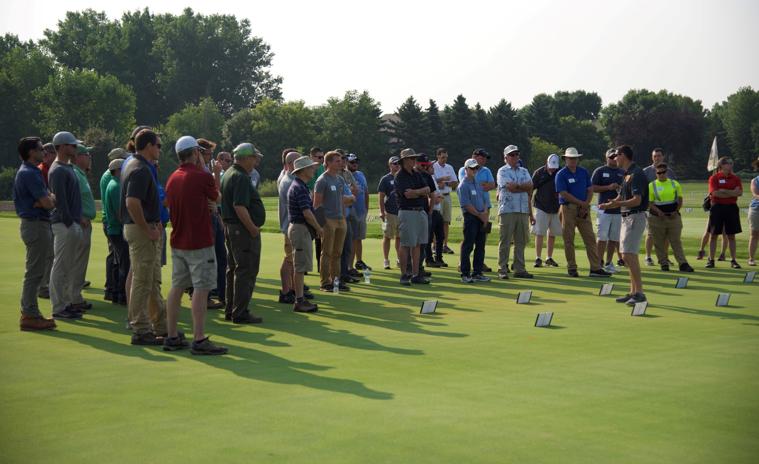 person on golf greens presenting research results to field day audience of 40 people